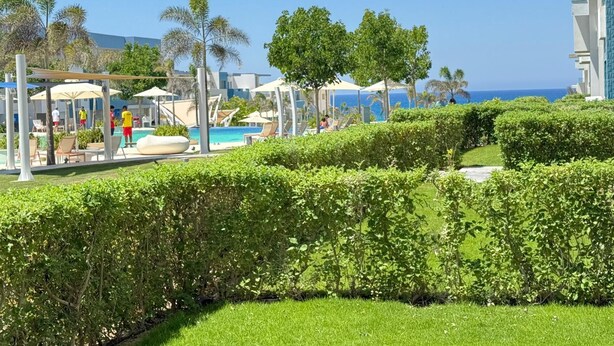 A resort with a swimming pool, lounge chairs, and a view of the ocean. - Fouka North Coast SA-2B-B02 (Marsa Matrouh)