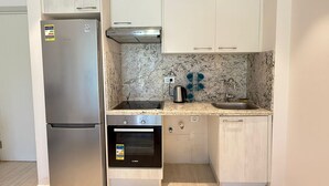 A compact kitchen with a refrigerator, oven, sink, and cabinets. - Fouka North Coast SA-2B-B02 (Marsa Matrouh)