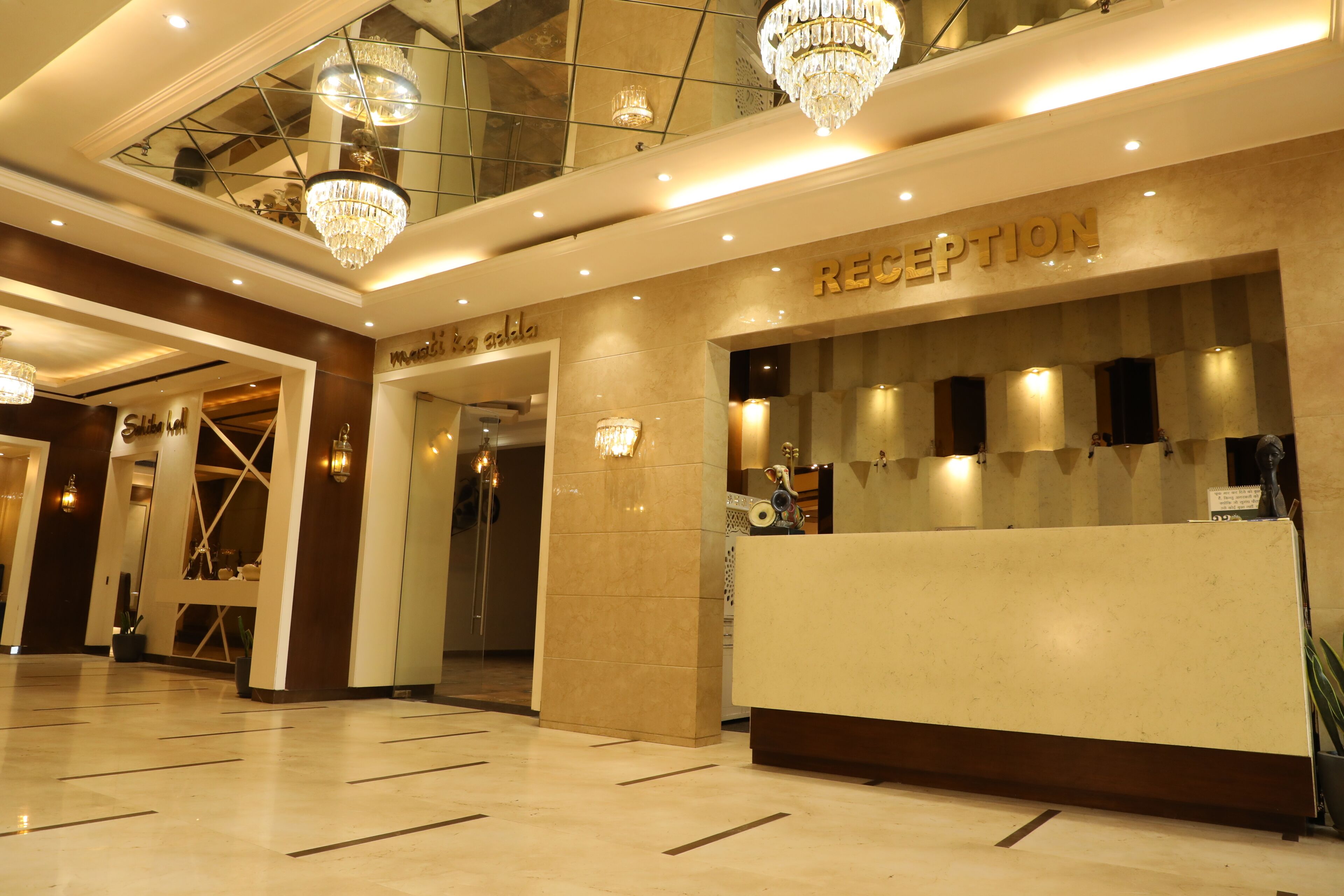 A reception area with a marble floor, a reception desk, and a chandelier.