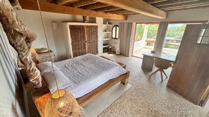 A bedroom with a bed, a desk, and a view of the outdoors. - SERENITY POOL VILLA IBIZA (Santa Eulària des Riu)