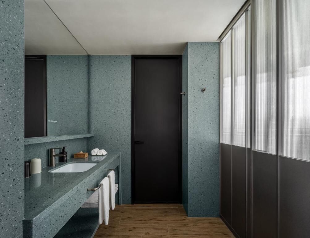 Un baño moderno con un lavamanos independiente, un espejo y una puerta.