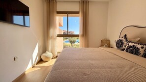 A bedroom with a large bed, a view of a pool, and a window with curtains. - PRESTIGIA Saphir Marrakech View Pool (Marrakech)