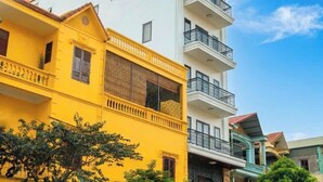 A hotel with multiple floors, balconies, and a clear sky. - Kevin Hung Hotel (Hoa Lu)