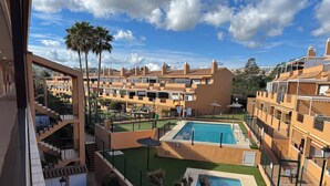 A residential area with multiple apartment buildings, a swimming pool, and a well-maintained lawn. - Suite Marina Sol (Casares Costa)