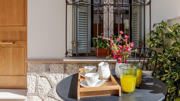A round table with a tray of breakfast items, a pitcher of orange juice, and a potted plant. - Cozy lodging in Málaga (Málaga)