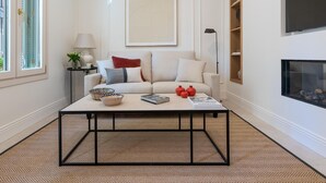 A living room with a sofa, coffee table, lamp, and a fireplace. - Cozy lodging in Málaga (Málaga)