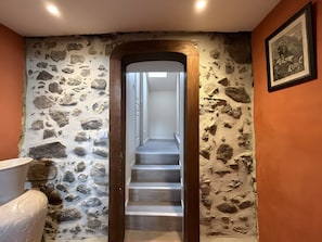 A stone wall with a wooden-framed doorway leading to a staircase. - Holiday Home “Le Pic Vert”: Mountain Views, Private Terrace & Wi-Fi (Salles)