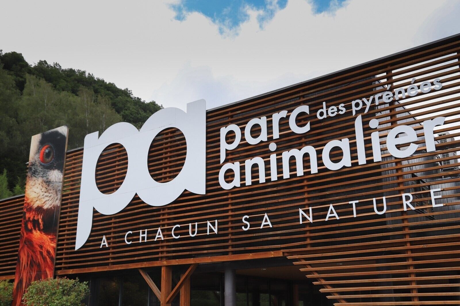 Une enseigne pour le «parc des Pyrénées» avec le texte «À CHACUN SA NATURE» et un grand logo en forme de «p».
