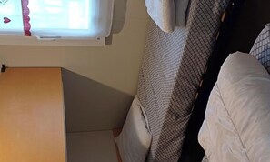 A bed with patterned bedding, a window with blinds, and a wooden nightstand. - Mobile-home pet friendly - 4 guests (Sournia)