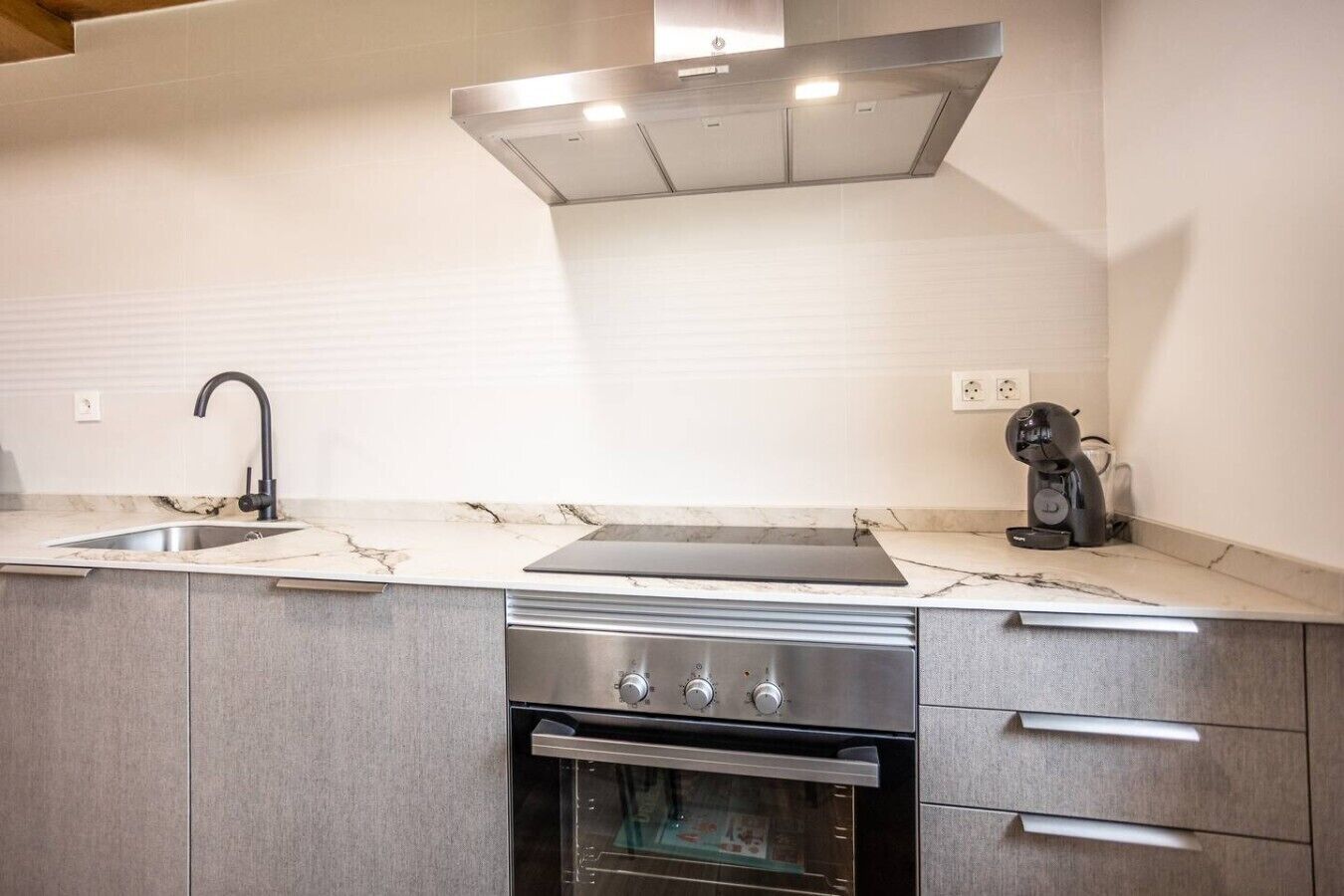Una cocina moderna con estufa, horno y lavavajillas integrados de acero inoxidable.