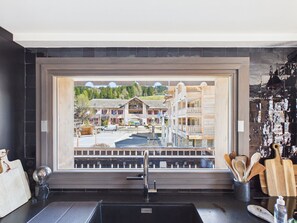 A kitchen with a large window, a sink, and wooden utensils. - Central apartment, spa access - 10 guests (Les Gets)