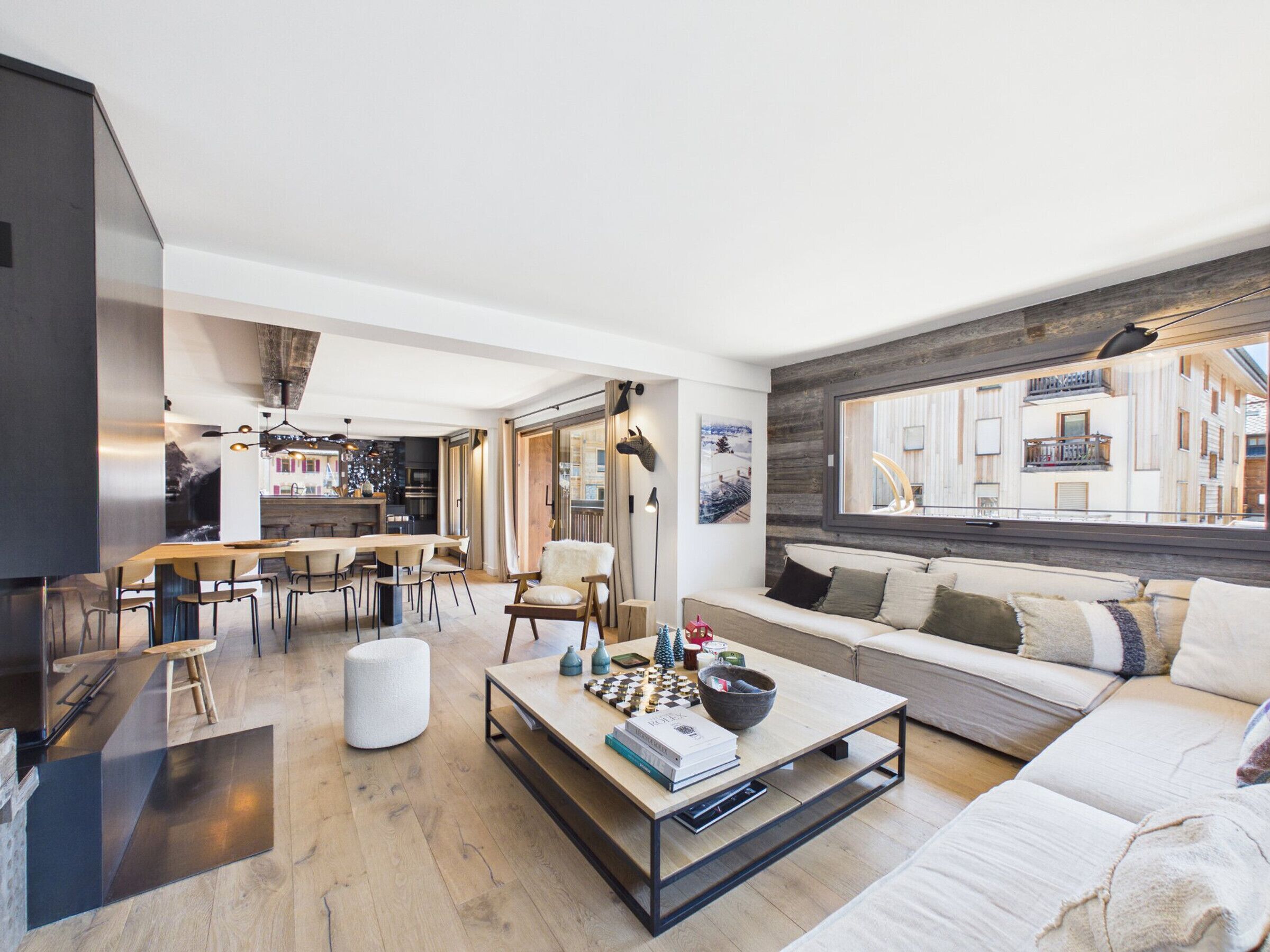A modern living room with a sofa, coffee table, and dining area.