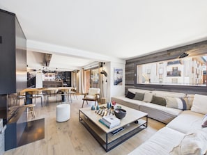 Ein modernes Wohnzimmer mit Sofa, Couchtisch und Essbereich.