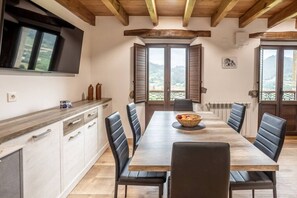 A dining area with a wooden table, black chairs, and a bowl of fruit. - Villa Camila - El Pajar (Villarraba)