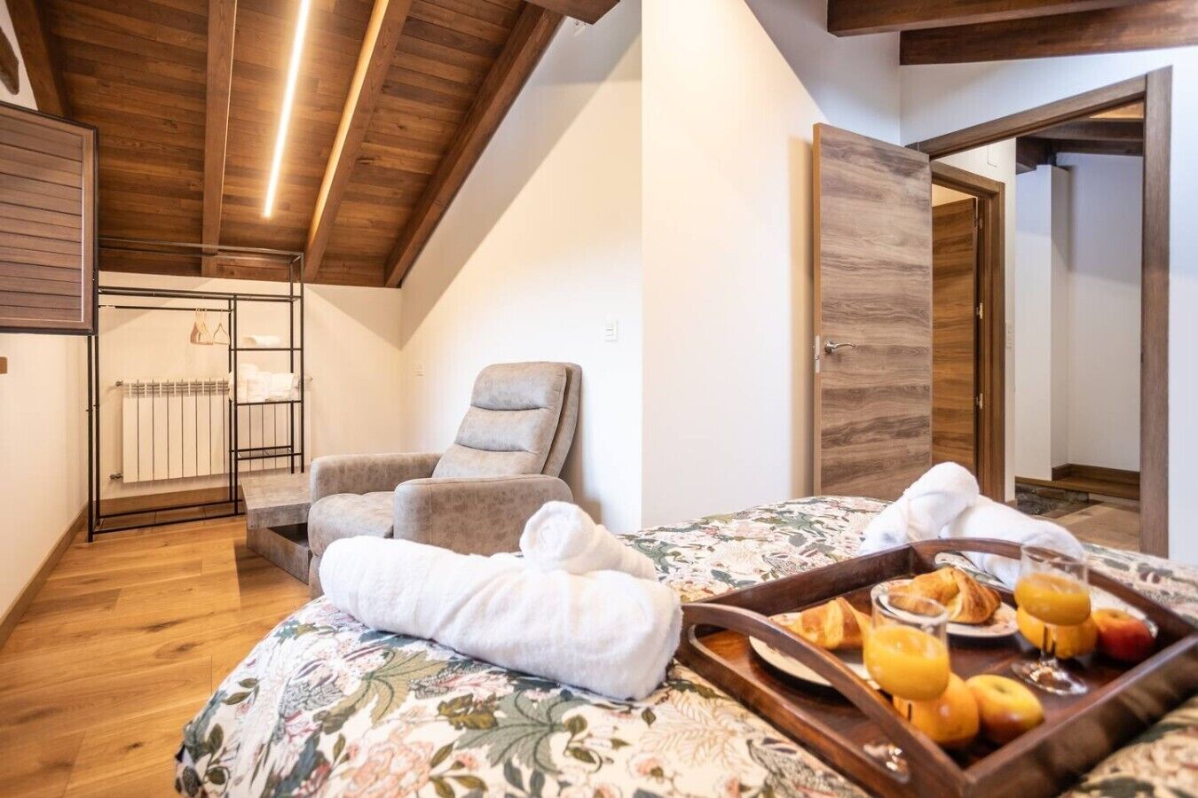 Un dormitorio con cama, una silla, una bandeja de fruta y un radiador.
