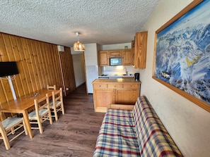 A compact living space with a dining area, kitchenette, and a sofa. - Functional studio, pets OK - 4 guests at the foot of the slopes (Les Deux Alpes)
