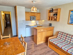 A compact kitchen with wooden cabinets, a microwave, and a coffee maker. - Functional studio, pets OK - 4 guests at the foot of the slopes (Les Deux Alpes)