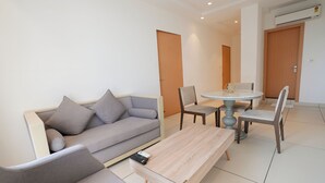 Una sala de estar moderna con un sofá, una mesa de centro y un comedor con sillas y una mesa.