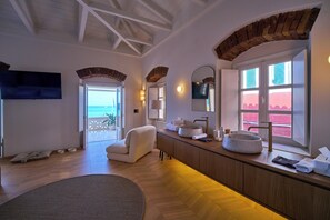 A modern bathroom with a large window, a bathtub, a sink, and a mirror. - 1-bedroom apartment in the heart of Parga (Parga)