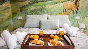 Un lit avec un plateau de nourriture, des oreillers et des serviettes.