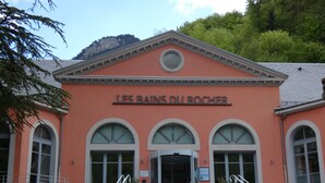 A building with arched windows and a sign reading 'LES BAINS DU ROCHER'. - Apartment 'L'estive Des 100 Lacs, Pool, Spa' with Mountain View, Private Terrace & Wi-Fi (Cauterets)