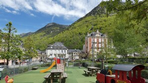 A playground with a slide, climbing wall, and picnic tables. - Apartment 'L'estive Des 100 Lacs, Pool, Spa' with Mountain View, Private Terrace & Wi-Fi (Cauterets)