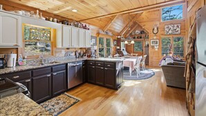 Une cuisine spacieuse avec des meubles en bois, un plan de travail en granit et un grand îlot central.