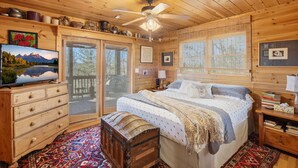 Une chambre dans une cabane en bois, comprenant un lit, une commode et un téléviseur.