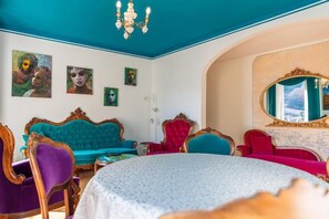 A room with a teal ceiling, a round table, and a large mirror with a gold frame. - Appartamento Splendore (Bellagio)
