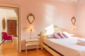 A bedroom with a bed, bedside tables, a mirror, and a chair. - Appartamento Splendore (Bellagio)