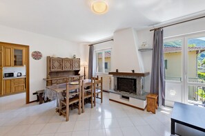 Een ruime woonkamer met een open haard, houten meubels en uitzicht op de omgeving.