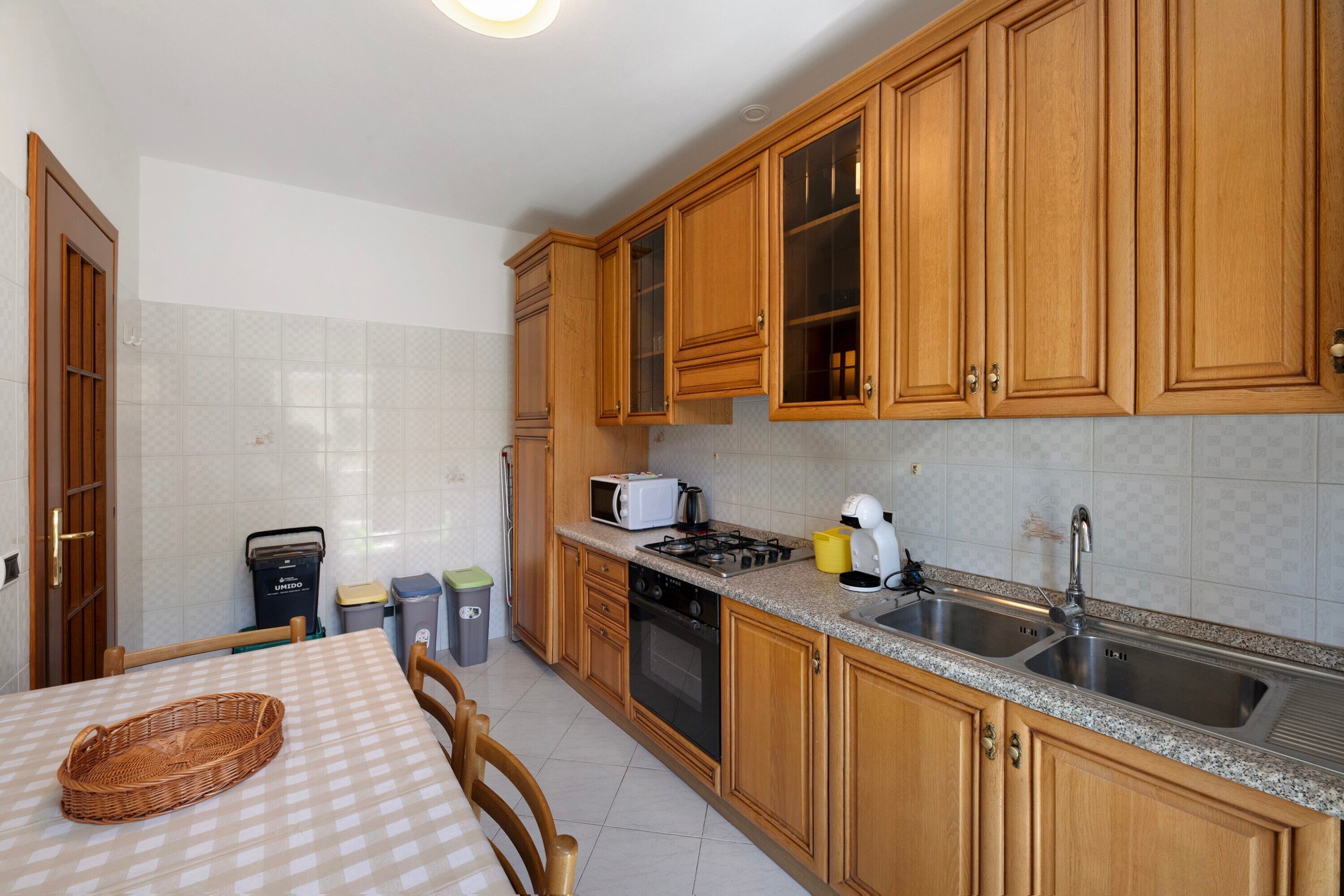 A kitchen with wooden cabinets, a microwave, a stove, and a sink.