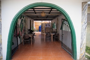 An arched doorway leading to a dining area with chairs and a table, a tiled floor, and a mural on the wall. - Bethel Bed and Breakfast Bantayan (Bantayan)