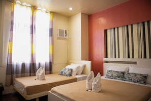 A hotel room with two beds, a window with curtains, an air conditioning unit, and a striped wall. - Bethel Bed and Breakfast Bantayan (Bantayan)