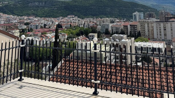 A cityscape with a view of mountains, buildings, and a tiled roof. - Cozy 1-bedroom apartment in fantastic Budva with AC (Budva)