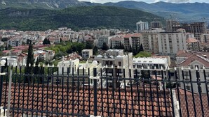 A cityscape with buildings, a mountain range, and a cloudy sky. - Cozy 1-bedroom apartment in fantastic Budva with AC (Budva)