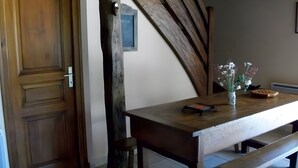 A wooden table with a vase of flowers, a framed picture on the wall, and a wooden bench. - Cottage (4/7 guests) with valley view in the heart of the volcano park (Jou-sous-Monjou)