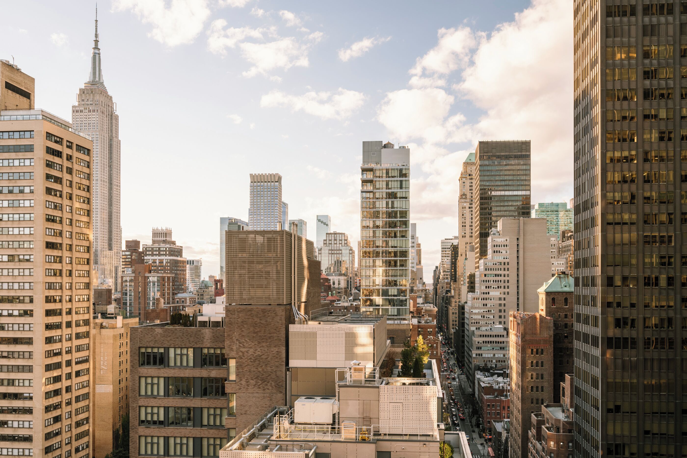 Un paysage urbain caractérisé par de nombreux immeubles de grande hauteur, dont un gratte-ciel remarquable surmonté d’une flèche, et une diversité de styles architecturaux.