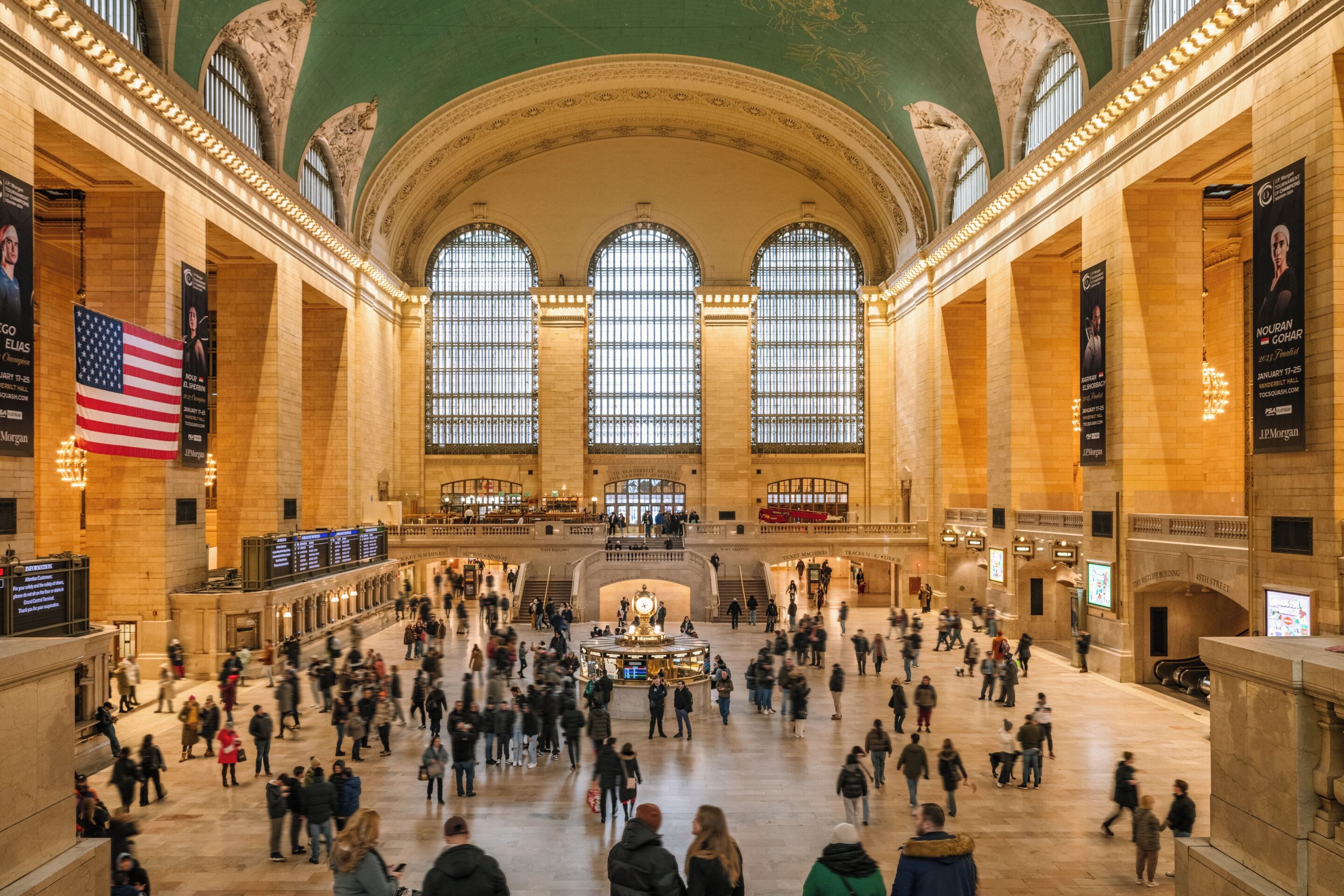 Une gare spacieuse, dotée de hauts plafonds, de grandes fenêtres en arc de cercle et d’une horloge centrale.