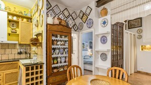 A kitchen with a wooden table, chairs, and a cabinet with dishes.