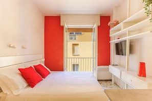 A hotel room with a bed, a TV, a balcony, and a window. - The Red Loft in Ponte Vecchio (Florence)