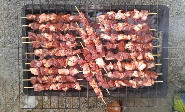Un grill avec de la viande en brochettes.