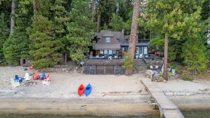Eine Strandlodge mit Anlegesteg, Kajaks und Sitzgelegenheiten im Freien.
