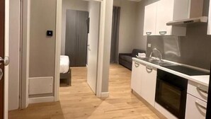 A modern apartment with a kitchen, a dining area, and a bedroom. - HH Tortona (Tortona)