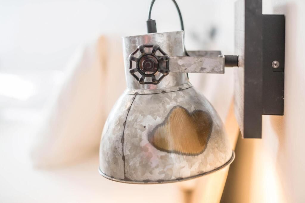 Una lámpara metálica de pared con un recorte en forma de corazón.