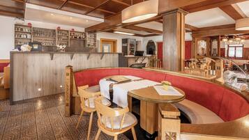 Un restaurante con barra de madera, zona de estar y suelo estampado.