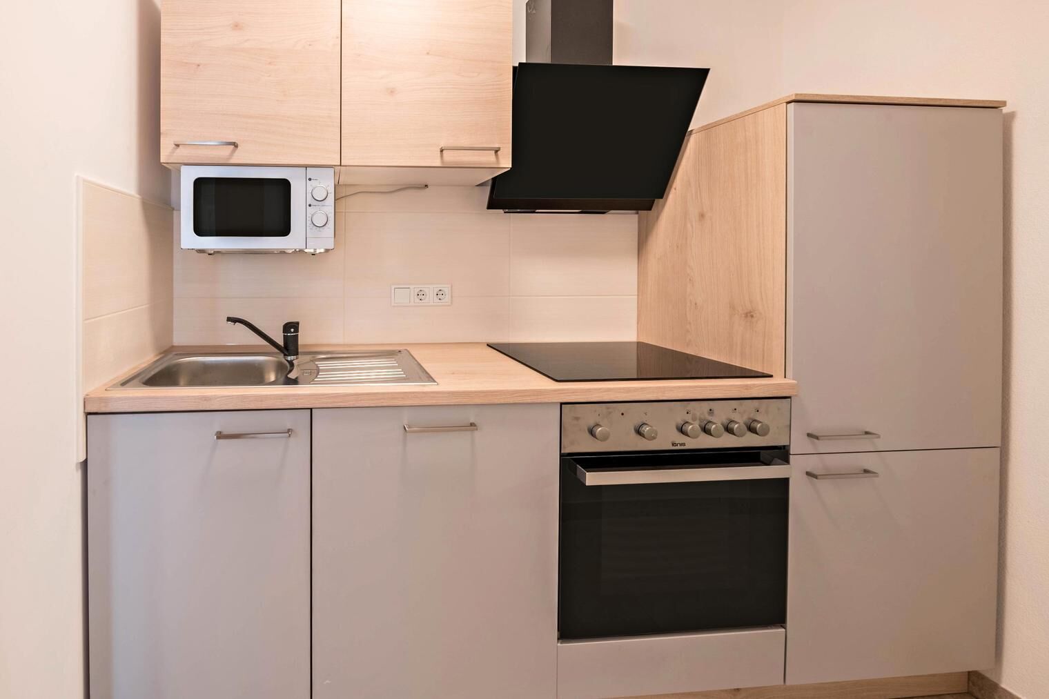 Una cocina compacta equipada con microondas, estufa, horno y lavaplatos.