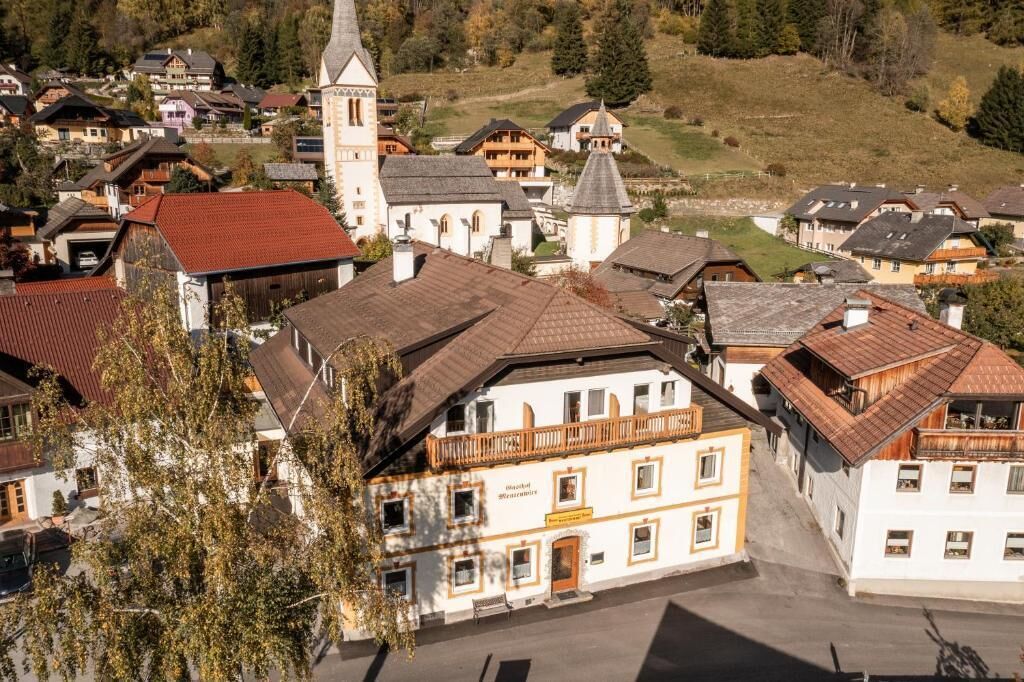 A traditional European town with a prominent church, a restaurant, and a variety of residential buildings.
