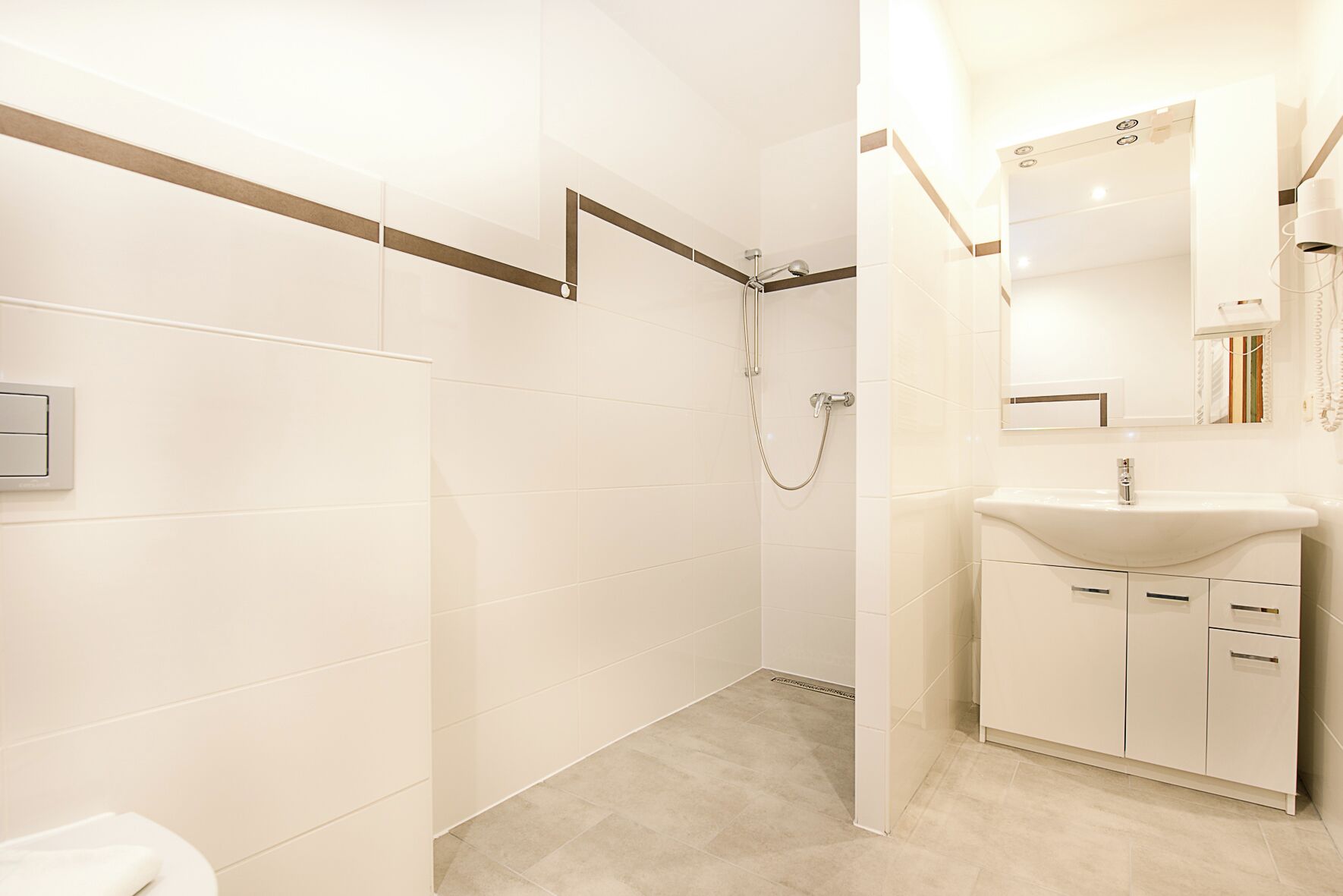 A modern bathroom with a shower, a sink, and a mirror.