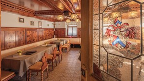 Un comedor con paneles de madera, una mesa larga y un vitral.